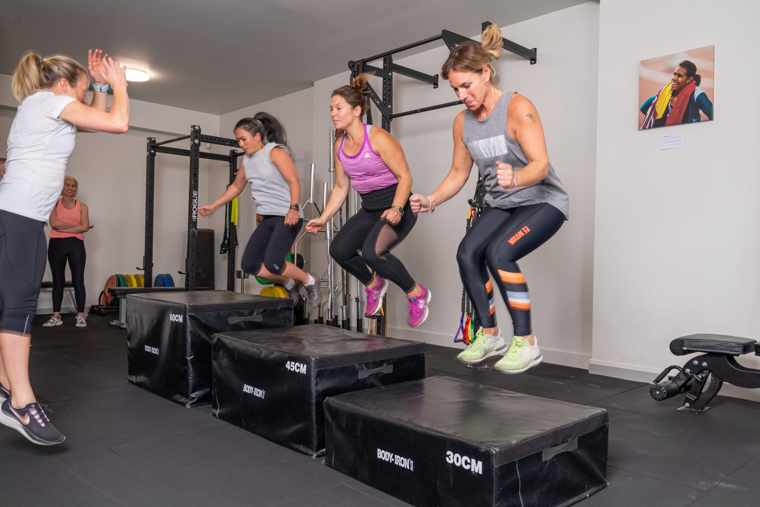 Women jumping from box in Small Group Fitness Training Class at Strong Women Can