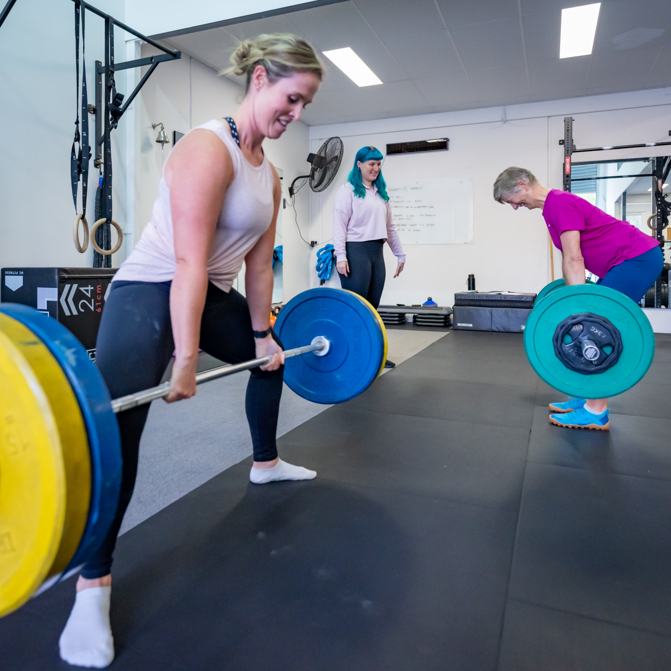 Woman sumo deadlift in small group training class
