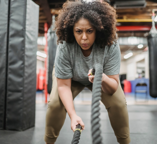Woman getting fit doing battle ropes